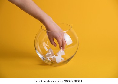 Hand randomly picking a winner from a glass bowl. Random name ballot, simple raffle. Secret Santa name pick - Shutterstock ID 2003278061