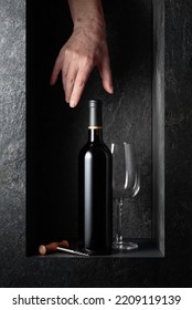 Hand Reach For A Bottle Of Red Wine. A Concept Image On The Theme Of Expensive Wines. 