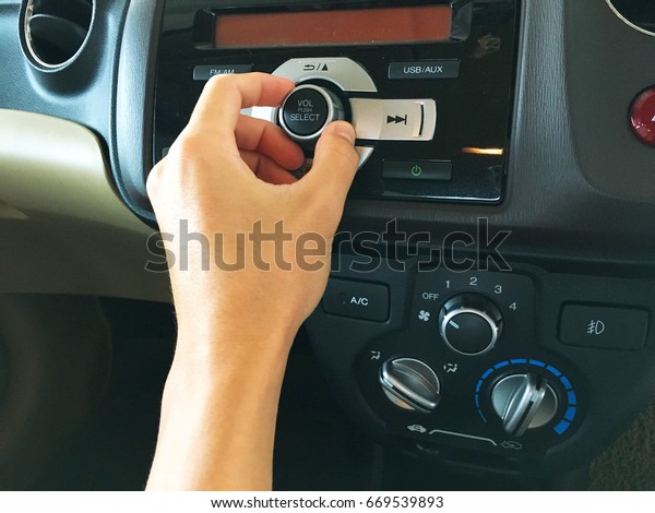 hand\
Reach out to adjust the audio controls in the\
car.