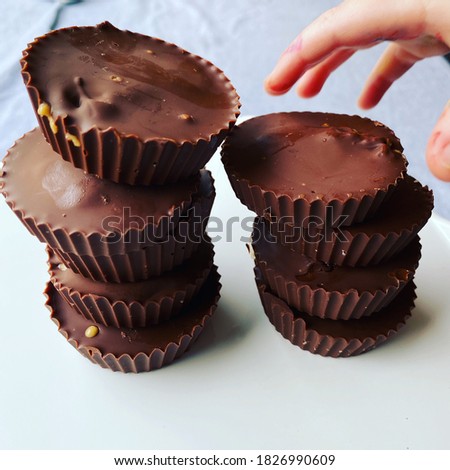 Hand reaching for chocolate covered peanut butter cups. 