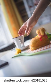 Hand reaching for a coffee, easter tulips and coffee on white planks, theme decoration