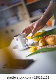 Hand reaching for a coffee, easter tulips and coffee on white planks, theme decoration