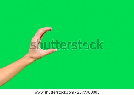 Hand reaching forward in a grabbing motion against a bright green background highlighting detailed gestures and focus