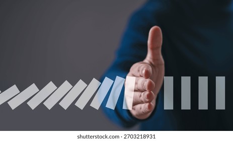 A hand reaching forward to stop falling domino pieces, symbolizing risk prevention, leadership, problem solving, crisis control, decision making, and strategic intervention in business situations.