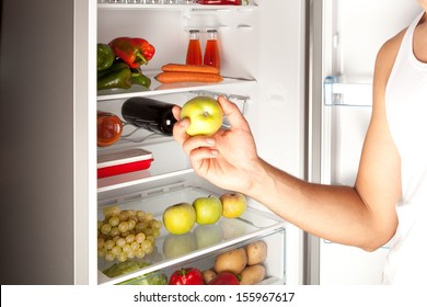 Hand Reaching For Green Apple In Refrigerator 