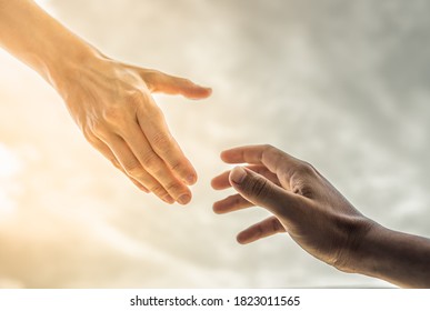 Hand reaching out to help someone out of the darkness into the light. Religion and salvation concept. 