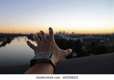 Hand Reaching Out To The Horizon During Dusk