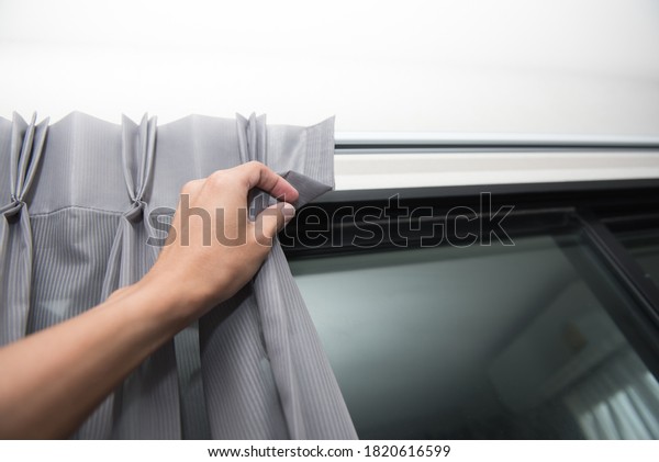 Hand\
reaching out to the luxury curtain in living\
room.