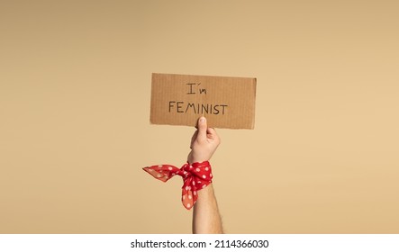 A Man´s Hand, With A Red Bandana With White Polka Dots On His Wrist, Holding A Sign Saying 