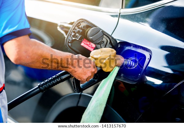 hand refilling the black car with\
fuel at the gas  station, black car in gas station, refilling the\
car with fuel at the refuel station, the concept of fuel\
energy