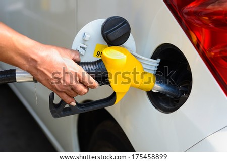 Hand refilling the car with fuel