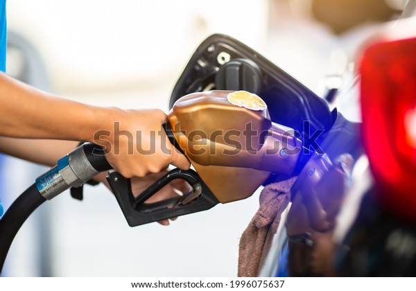 hand refilling the car with fuel
at the gas  station, car in gas station, refilling the car with
fuel at the refuel station, the concept of fuel
energy.