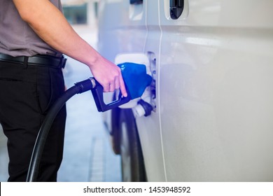 Hand Refilling The White Van With Fuel At The Gas Station. Oil And Gas Energy.