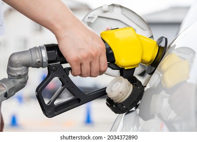 A Hand To Refuel A Car With High-octane Gasoline.