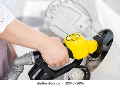 A Hand To Refuel A Car With High-octane Gasoline.