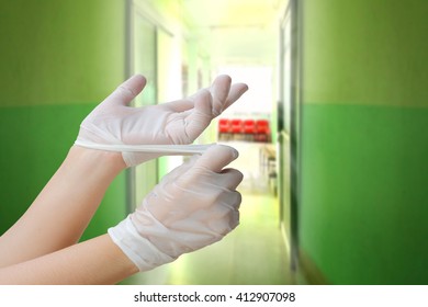 Hand Remove Medical Gloves With Blur Chair In Hospital Background