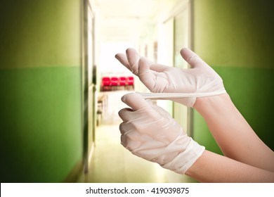 Hand Remove Medical Gloves With Blur Chair In Hospita6l Background