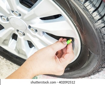 Hand Is Removing A Green Tire Valve Caps For Nitrogen Tire Inflation Service