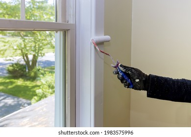 Hand Of Repairman Painting With Gloves A Paint Roller In The Painting Window Molding Trim