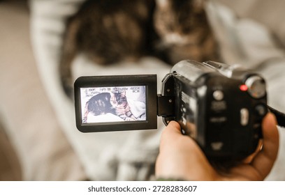 Hand with retro camcoder with LCD flip screen. Y2k technology concept.