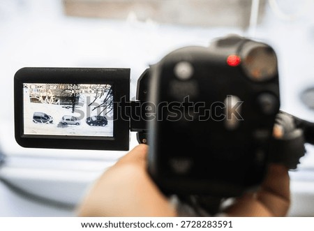 Hand with retro camcoder with LCD flip screen. Y2k technology concept.