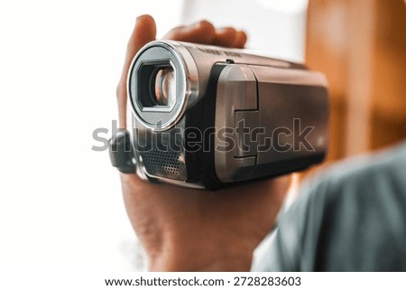 Hand with retro camcoder with LCD flip screen. Y2k technology concept.