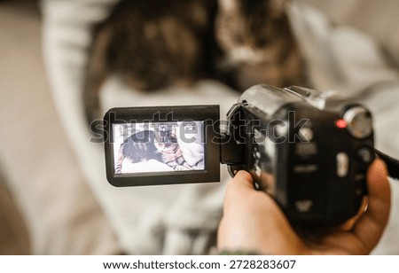 Hand with retro camcoder with LCD flip screen. Y2k technology concept.