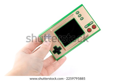 In the hand of a retro game console on a white background