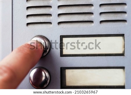 Hand ringing on doorbell. Macro phot