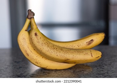 Hand of ripe bananas in kitchen countertop