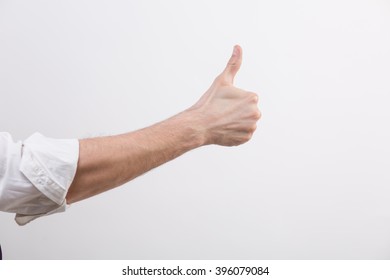 Hand With Rolled Sleeve In A Studio With Thumb Up