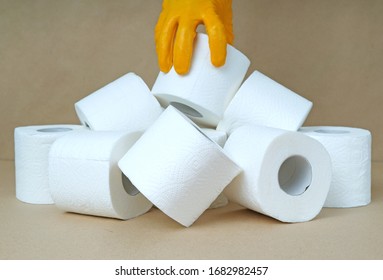 Hand In Rubber Glove Reaches For Toilet Paper In Covid-19 Quarantine Period