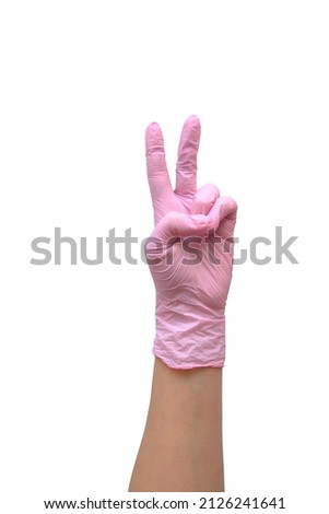 hand in rubber pink glove shows the sign of the world, isolated on a white background, layout with copy space