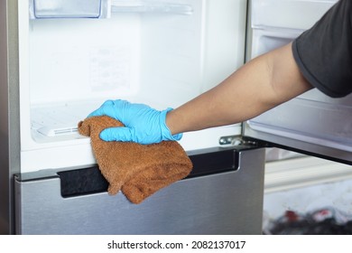 Hand In Rubber Protective Blue Glove Uses Cloth To Clean Inside Of Refrigerator. Concept : Cleaning And  Maintenance  Household Appliance For Hygiene ,gain Efficiency Or Save Energy Of Electric Power.