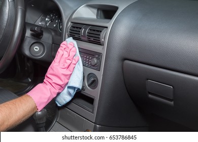 Hand In Rubber Protective Glove With Rag Cleaning A Dusty Car Dashboard. Early Spring Cleaning Or Regular Clean Up. 