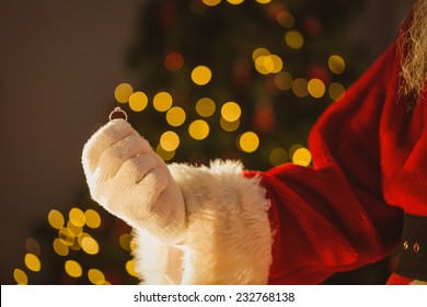 Hand Of Santa Claus Holding Engagement Ring At Home In The Living Room