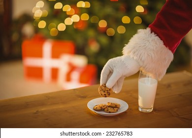 Hand Of Santa Claus Picking Cookie On The Table At Home