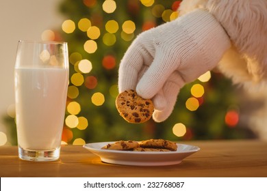 Hand Of Santa Claus Picking Cookie On The Table At Home