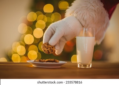 Hand Of Santa Claus Picking Cookie On The Table At Home