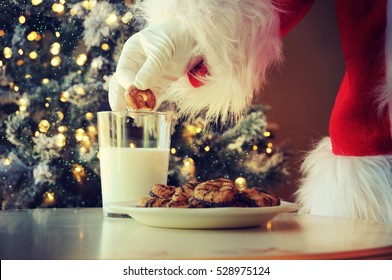 Hand Of Santa Claus Picking Cookie On The Table At Home