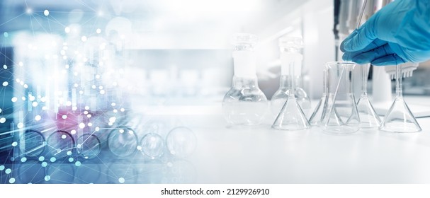 hand of scientist in blue glove with test tube and flask in medical chemistry lab and information banner background	 - Shutterstock ID 2129926910