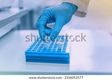 Hand of scientist holding dna test tube, research of biomaterial in the laboratory, Eco and genetic engineering