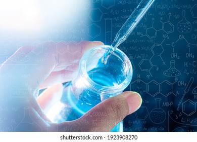hand of scientist holding flask with lab glassware and test tubes in chemical laboratory background, science laboratory research and development concept - Shutterstock ID 1923908270