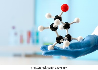 hand of scientist holds a molecular model at the lab - Powered by Shutterstock