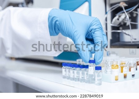 Hand of scientists arrange vials of samples in order of sample or prepare samples for analysis by Liquid Chromatography mass spectrometry LC-MS analysis in lab. LCMS, HPLC used for scientific research