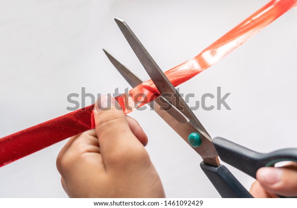 hand with scissors cut the red ribbon tape, open\
ceremony concept