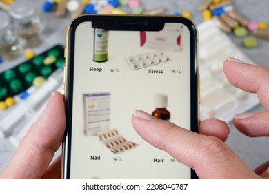 Hand Scrolling Through The Site In Medicines, Buying Medicines Online On Pills And Stethoscope Background,The Concept Of Online Pharmacy, Closeup