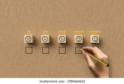 Hand Selecting A Happy Emoticon Symbolizing A Good Review On Paper Background