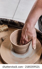 Hand Of Senior Woman Sculpting Clay Vase On Potter's Wheel. Elderly People Concept. Place For Text