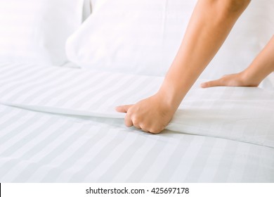 Hand Set Up White Bed Sheet In Room